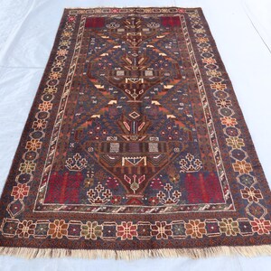 Può includere: Un tappeto persiano tradizionale con sfondo blu scuro e intricati motivi floreali in tonalità di rosso, marrone e crema. Il tappeto ha un bordo con frange.