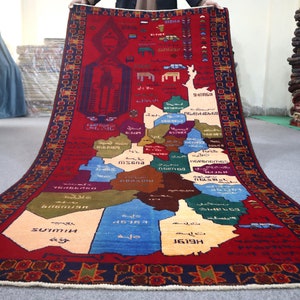 Puede incluir: Una alfombra roja, azul y verde con un mapa de Armenia en ella. El mapa está etiquetado con los nombres de las diferentes provincias en armenio. La alfombra tiene un borde negro y blanco.