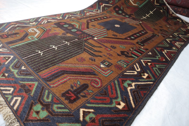 May include: A brown, blue, green and red patterned rug with a geometric design. The rug has a fringed border.