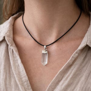 Pendentif quartz naturel porté par femme sur cordon noir  EN : Natural quartz crystal pendant worn by woman on black cord