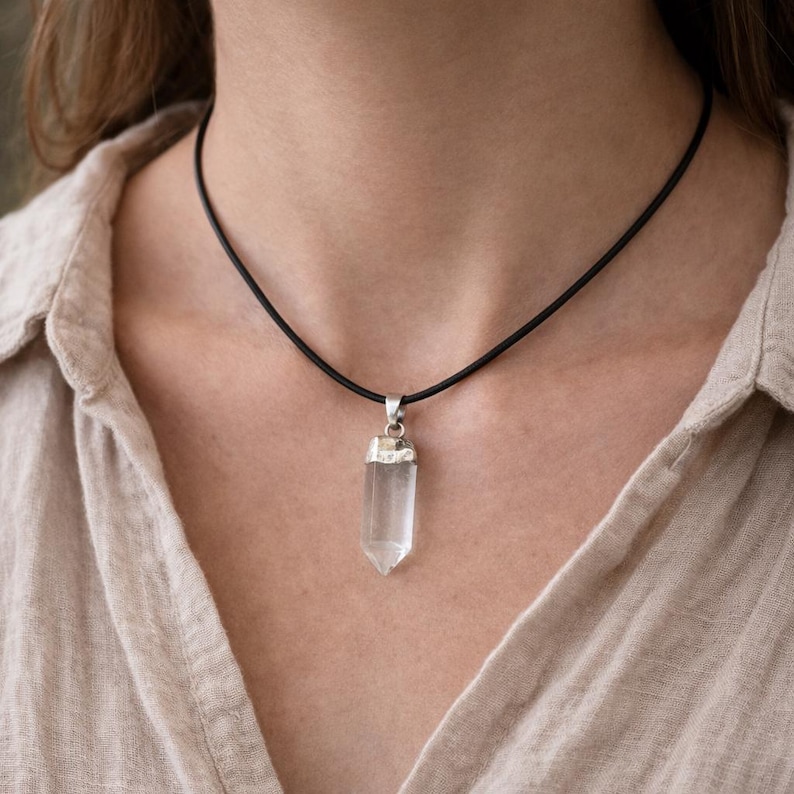 Pendentif quartz naturel porté par femme sur cordon noir  EN : Natural quartz crystal pendant worn by woman on black cord