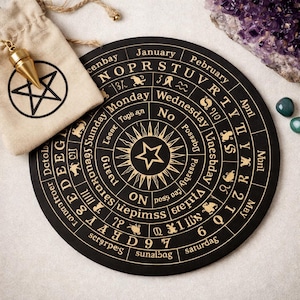 Puede incluir: Un tablero de adivinación negro con letras doradas y un diseño de estrella central. Incluye una bolsa de cordón beige con un pentagrama y un péndulo dorado. También hay amatista y piedras verdes.