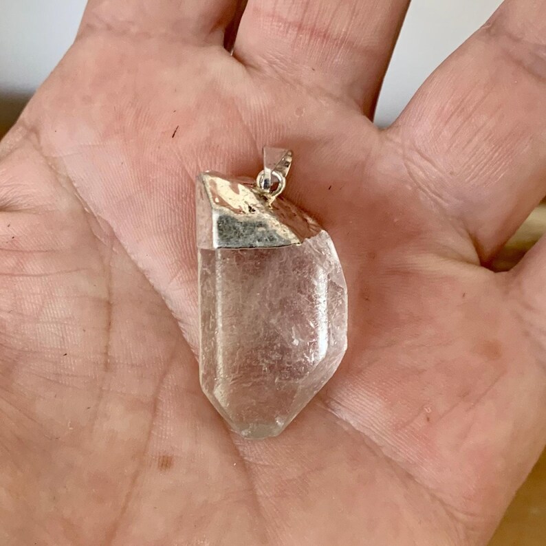 Pendentif pointe de quartz naturel brut en gros plan  EN : Raw natural quartz point pendant close-up