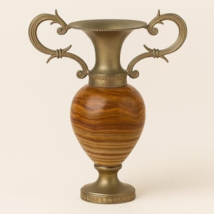 May include: A decorative vase with a bronze-colored metal top and base, and two ornate handles. The body of the vase is a warm brown with a wood grain pattern. The vase stands approximately 12 inches tall.