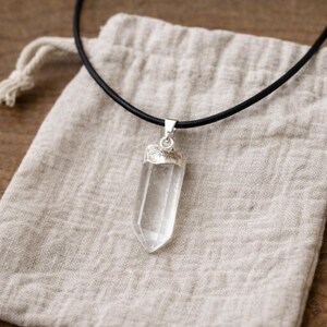 Pendentif quartz naturel présenté sur bourse en coton

EN :
Natural quartz crystal pendant displayed on cotton pouch