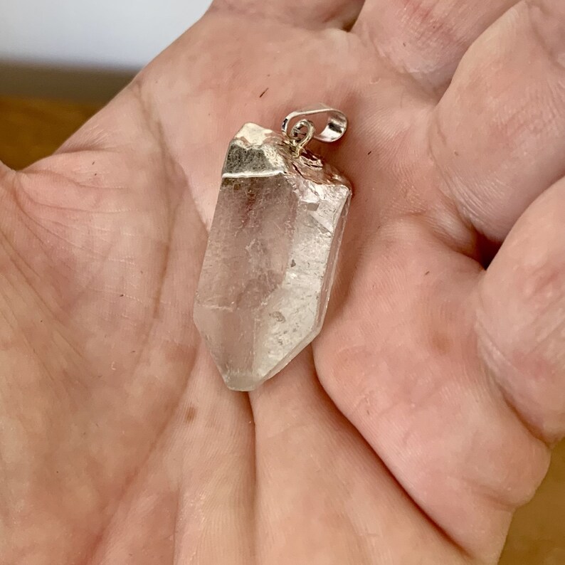 pendentif en quartz brut naturel dans la main

EN :
natural raw quartz pendant in hand