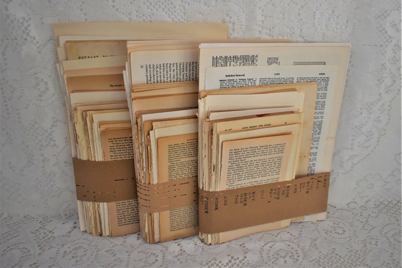May include: A stack of vintage book pages, bundled together with brown paper tape. The pages are cream-colored and have printed text.