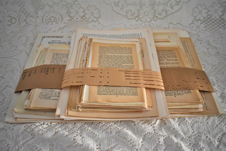 May include: A stack of old, yellowed book pages tied together with brown paper and a label that reads "DIY Book Pages - 100+ Pages - Junk Journal - Mixed Sizes".