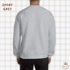K&ouml;nnte beinhalten: Ein grauer Pullover mit langen &Auml;rmeln. Der Pullover ist aus weichem, bequemem Material und hat eine lockere Passform.