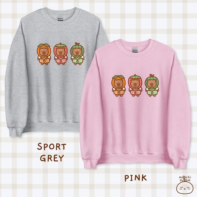 K&ouml;nnte beinhalten: Zwei Sweatshirts mit einem Motiv von drei B&auml;ren, die Fr&uuml;chte auf dem Kopf tragen. Das Sweatshirt links ist grau und tr&auml;gt den Schriftzug "Sport Grey". Das Sweatshirt rechts ist rosa und tr&auml;gt den Schriftzug "Pink".