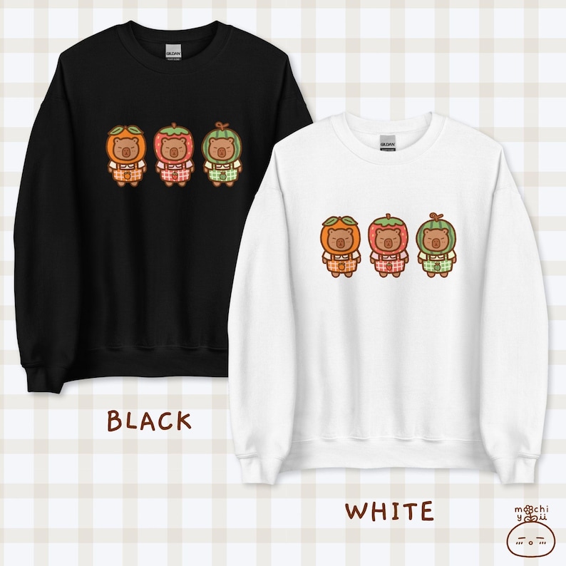 K&ouml;nnte beinhalten: Zwei Sweatshirts, eines schwarz und eines wei&szlig;, mit einem Motiv von drei Cartoon-B&auml;ren, die Fruchtkost&uuml;me tragen. Die B&auml;ren tragen orange, rote und gr&uuml;ne Fruchtkost&uuml;me. Der Text "BLACK" und "WHITE" befindet sich unter jedem Sweatshirt.