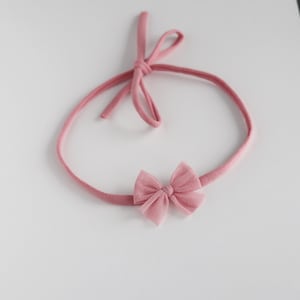 Puede incluir: Una diadema rosa con un lazo de tul rosa. La diadema está hecha de un material suave y elástico, perfecta para bebés y niños pequeños.