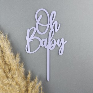 May include: Purple acrylic cake topper with the words "Oh Baby" in a cursive font.