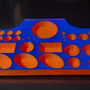 May include: A blue and orange plastic organizer with multiple compartments of different sizes. The organizer has the words "HO2", "AJK", "PO4", "C3", and "M8" printed on the bottom.