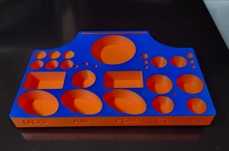 May include: A blue and orange plastic organizer with multiple compartments of different sizes. The organizer has the words "HO2", "AJK", "PO4", "C3", and "M8" printed on the bottom.