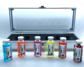 May include: A silver case with a clear lid containing seven small glass vials with colorful liquids. Each vial has a label with the word "Umbrella" and a number. The labels also include text such as "T-Virus", "S-Virus", "Type-1 Plasma", and "Uroboros".