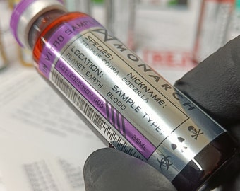 May include: A silver vial labeled "MONARCH" with a skull and crossbones symbol. The vial contains a sample of blood from a Titanus Gojira Godzilla, labeled "SAMPLE TYPE: BLOOD".