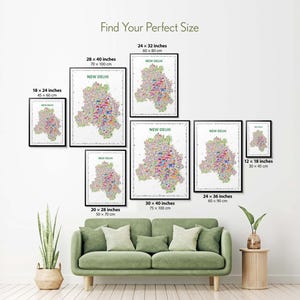 Colorful New Delhi illustrated map poster size guide showing seven framed print sizes from 12 x 18 to 30 x 40 inches above a green sofa.
