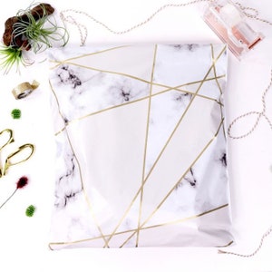 May include: White poly mailers with a marble pattern and gold geometric lines. The mailers are flat and have a self-adhesive closure.