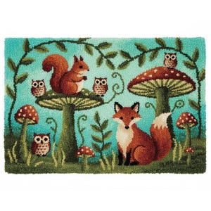 Op de afbeelding: Een grillig tapijt met een bosscène met een vos, een eekhoorn en uilen. Het ontwerp bevat paddenstoelen en bladeren tegen een turquoise achtergrond. Het tapijt lijkt handgetuft te zijn.