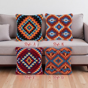May include: Four square decorative throw pillows with geometric patterns in various colors, including black, orange, blue, and red. Each pillow is labeled with a style letter: A, B, C, and D. The pillows are displayed on a gray sofa.