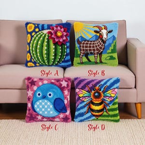Könnte beinhalten: Vier dekorative Zierkissen mit gestickten Designs. Zu den Stilen gehören ein Kaktus mit einer Blume, eine Ziege mit Bergkulisse, eine blaue Eule mit Sternen und eine Biene. Jedes Kissen hat den Stilnamen aufgedruckt.