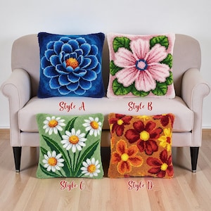 May include: Four square throw cushions with floral patterns. Designs include a blue flower, a pink flower, daisies on green, and orange and red flowers. The cushions are on a beige sofa. Text below each cushion reads "Style A", "Style B", "Style C", and "Style D".