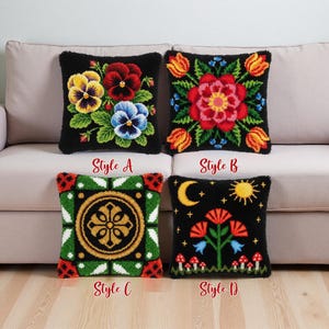 Pode incluir: Quatro almofadas decorativas com fundos pretos são exibidas em um sofá bege. Cada almofada apresenta um design floral ou geométrico único e colorido. Os estilos A, B, C e D são rotulados abaixo de cada almofada.