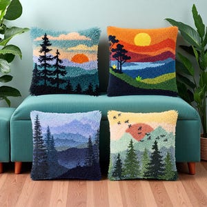 May include: Four square cushions with landscape designs. Each cushion features a different sunset scene with trees, mountains, and a colourful sky. The cushions are made of a textured material and are displayed on a teal bench.