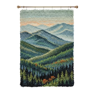 Könnte beinhalten: Ein strukturiertes Wandbehang, das eine Berglandschaft darstellt. Das Kunstwerk zeigt Schichten von blauen und grünen Bergen unter einem hellblauen Himmel mit einem Hauch von Orange. Das Stück ist an einer dekorativen, bronzefarbenen Stange befestigt.
