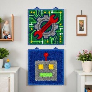 Könnte beinhalten: Zwei quadratische Wandbehänge. Einer zeigt einen roten Schraubenschlüssel über einem grauen Zahnrad auf einer grünen Leiterplatte. Der andere zeigt einen blauen Roboter mit grauem Gesicht, gelben Augen und einer roten Antenne.