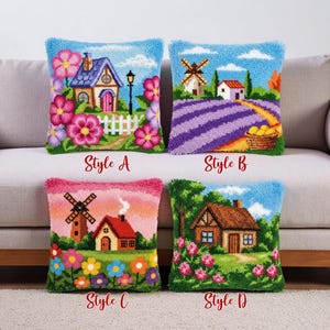Könnte beinhalten: Vier dekorative Zierkissen mit farbenfrohen, strukturierten Designs. Jedes Kissen zeigt eine andere Landschaftsszene: ein Haus mit Blumen, ein Lavendelfeld mit einer Windmühle, eine Windmühle mit einem Haus und ein Cottage mit Blumen. Jedes Kissen hat eine Stilbezeichnung.