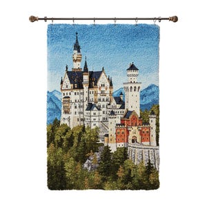 May include: A tapestry depicting a detailed illustration of Neuschwanstein Castle, with white walls, dark blue roofs, and red accents. The castle is set against a blue sky and green trees, mounted on a decorative rod.