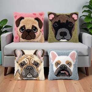 以下が含まれることがあります： パンチニードルで犬の顔が描かれた4つの正方形のクッション。左上はピンク地にベージュのパグ、右上はオリーブグリーン地に茶色と黒の犬、左下はフォーンカラーのフレンチブルドッグ、右下は水色地に白いフレンチブルドッグのテクスチャーデザインです。