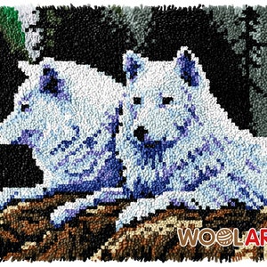Puede incluir: Un primer plano de una alfombra que representa dos lobos blancos con detalles azules, tumbados en un entorno de bosque. La alfombra est&aacute; hecha de hilo en bucle y tiene el texto "WOOLART" en la esquina inferior derecha.