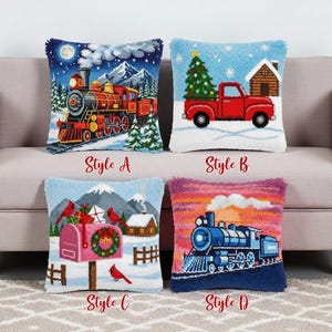 May include: Four decorative cushions with winter scenes. Style A shows a red train, Style B a red truck with a Christmas tree, Style C a mailbox with cardinals, and Style D a blue train. Each cushion has a textured, fringed edge.
