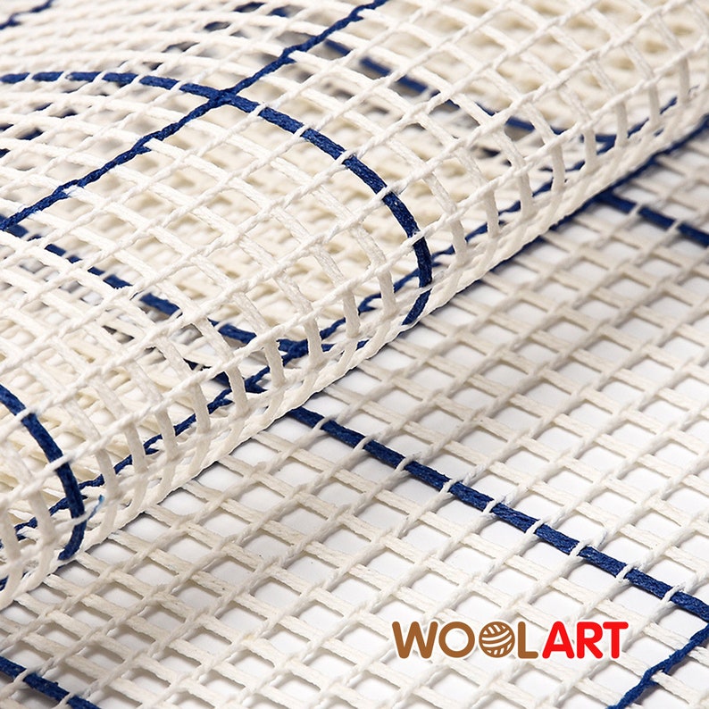Puede incluir: Lienzo blanco con un patr&oacute;n de cuadr&iacute;cula azul. El lienzo est&aacute; doblado, mostrando el lado posterior. El lienzo est&aacute; etiquetado con "WOOLART" en la esquina inferior derecha.