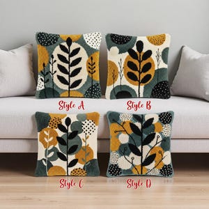 Peut inclure: Quatre coussins décoratifs avec des motifs botaniques. Chaque coussin présente un motif différent de feuilles, de cercles et de points dans des tons de noir, or, crème et sarcelle. Les coussins sont étiquetés "Style A", "Style B", "Style C" et "Style D".