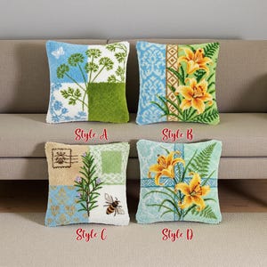 Könnte beinhalten: Vier quadratische dekorative Zierkissen mit gestickten Designs. Stile umfassen Blumen-, Pflanzen- und Insektenmotive. Jedes Kissen hat eine einzigartige Farbpalette, darunter Blau, Grün, Gelb und Beige. Die Kissen sind mit dem Text "Style A", "Style B", "Style C" und "Style D" beschriftet.
