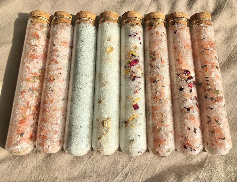 8 x 45ml clear glass test tubes with round bottom with cork stoppers. All 8 tubes are filled with different scent bath salts. Lavender, lavender eucalyptus, rose, eucalyptus peppermint, chamomile, lavender rosemary, oatmeal and vanilla, eucalyptus.