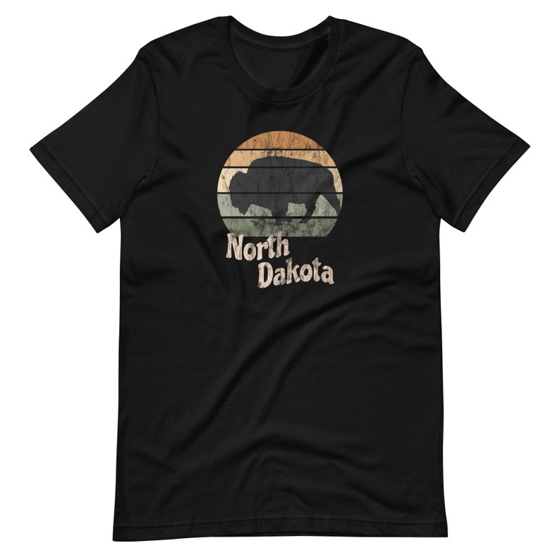 May include: Black t-shirt with a vintage-style graphic of a bison silhouette in front of a sunset with the text "North Dakota" underneath.