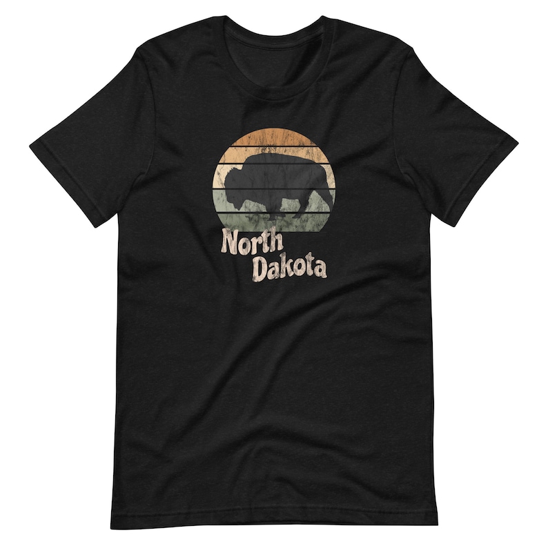 May include: Black t-shirt with a vintage-style graphic of a bison silhouette in front of a sunset with the text "North Dakota" underneath.