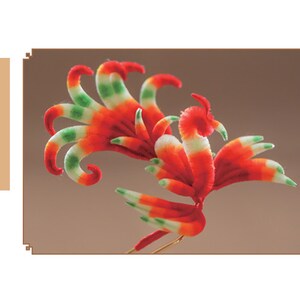 May include: A colorful, handcrafted bird sculpture with red, white, and green accents. The bird has a long, curved tail and is set against a brown background. The text on the left reads "Textile Animals".