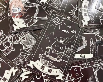 May include: A collection of black and white tarot cards. The cards feature detailed illustrations and text, including the words "The Fool" and "The Magician". The artwork includes images of a cat, mountains, and other symbolic elements.
