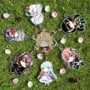 May include: A collection of anime-style acrylic keychains featuring various characters. Each keychain has a unique design with vibrant colors and detailed artwork. The keychains are connected by silver chains and arranged on a bed of green grass with flower petals.