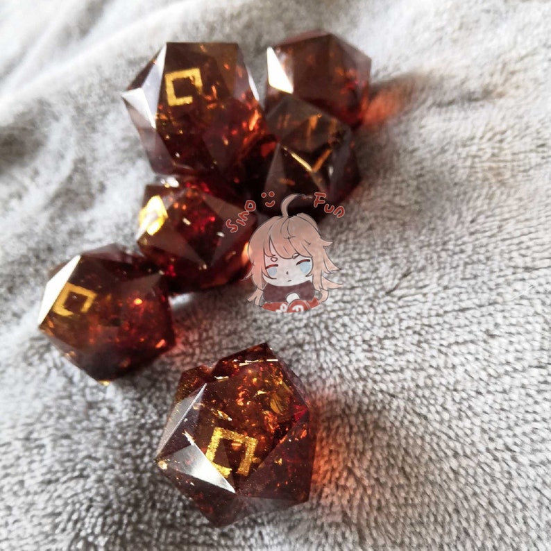 May include: A set of six brown, multi-faceted dice with gold-colored markings. The dice are made of resin and have a sparkly, translucent appearance.