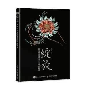 May include: A book cover with a black background and a colourful flower design. The title of the book is "绽放" which translates to "Bloom" in English. The book is about flower design and crafting.