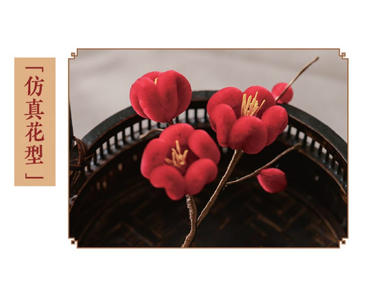 May include: Red artificial flowers with yellow stamens are arranged in a dark, decorative basket. The flowers are in full bloom, with a soft, velvety texture. The image includes text in a vertical column.