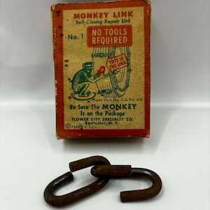 May include: An aged box of "Monkey Link" self-closing repair links. The box is orange and brown with text and a monkey graphic. Below the box are three rusty metal links. The text on the box reads "No Tools Required."