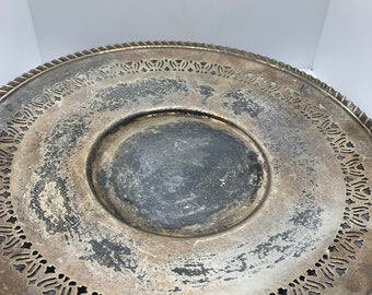 May include: A silver serving tray with a decorative, openwork border. The tray has a slightly tarnished finish.